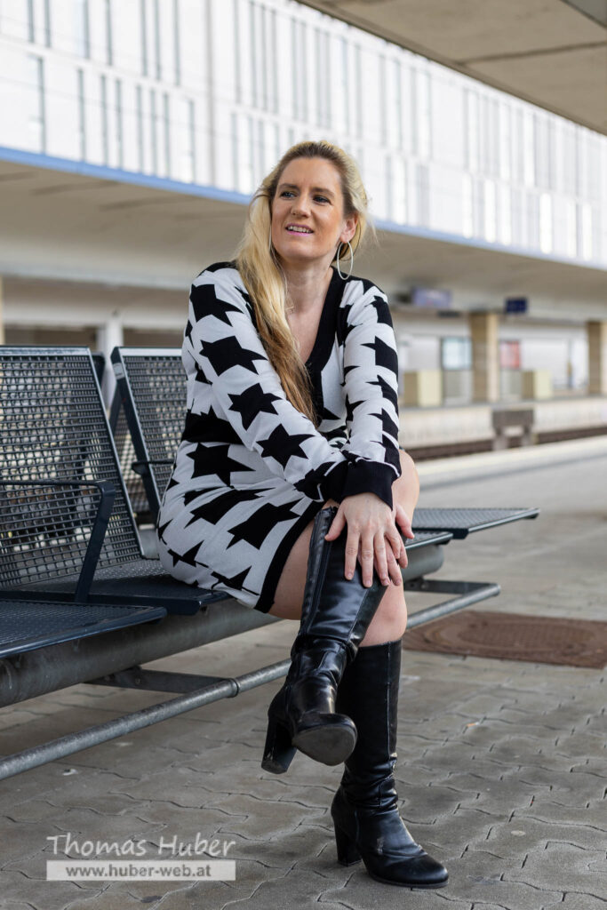 Lovely Crazy Woman sitzt auf Bank am Bahnsteig